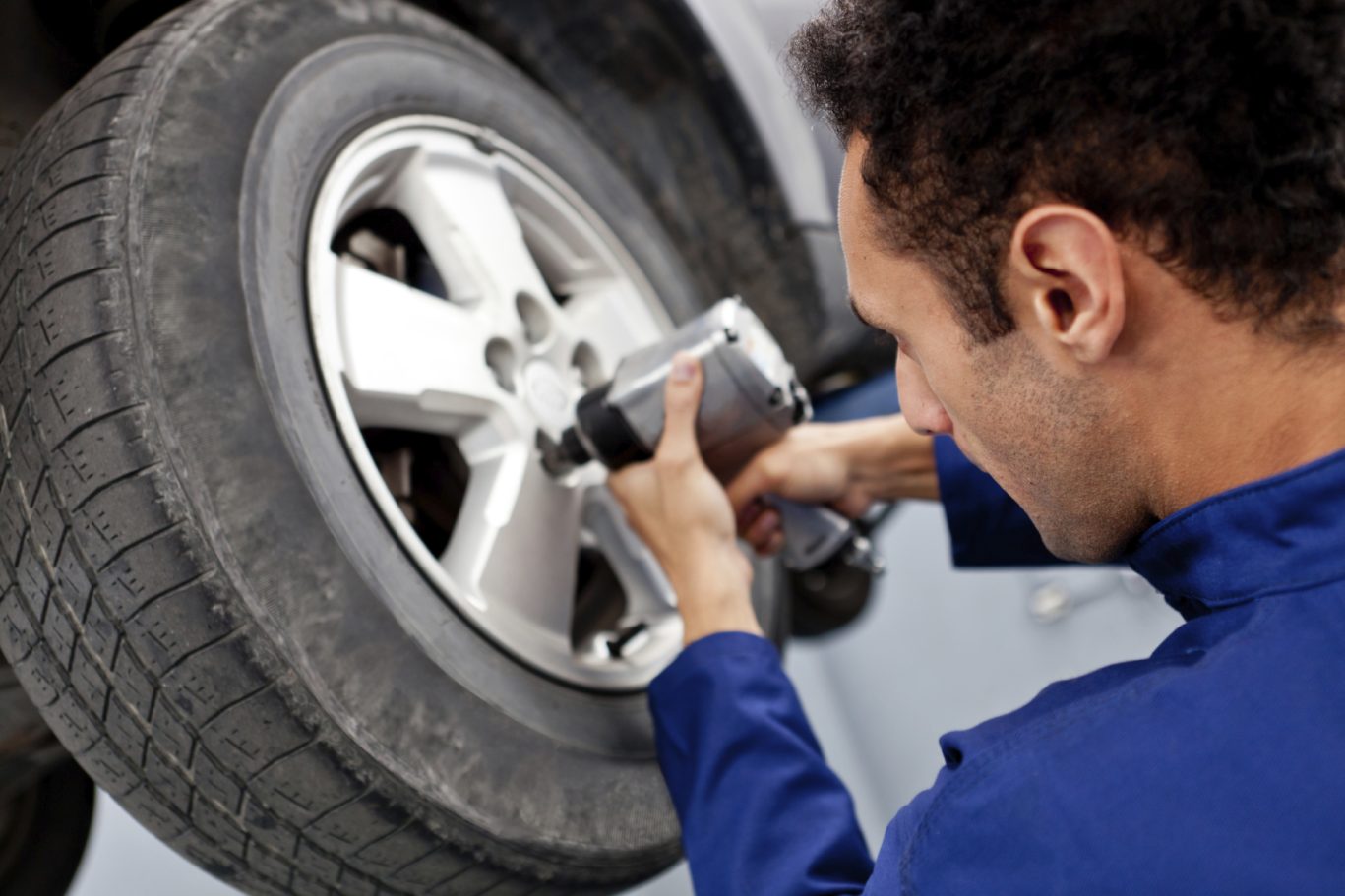 A mechanic using a power tool to remove a wheel from a vehicle. repair car repair, repairs on cars. Garages in Coventry.